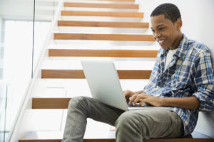 boy using laptop on the stairs