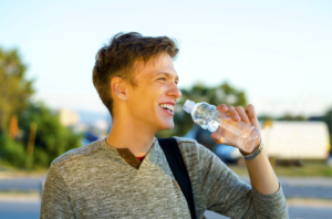 man drinking water and smiling