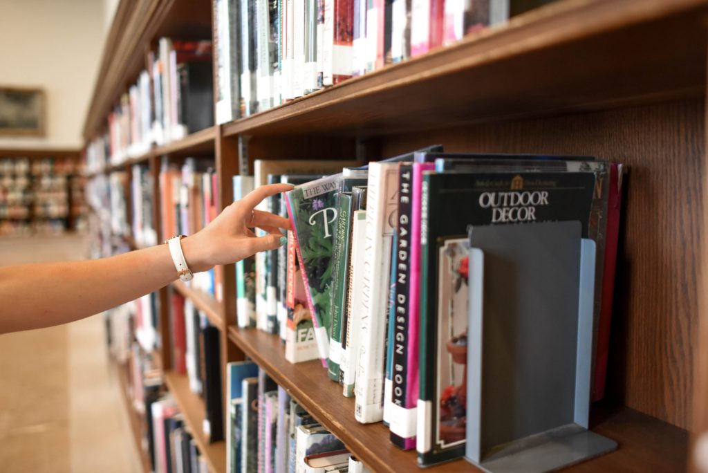 choosing a book from the library shelf