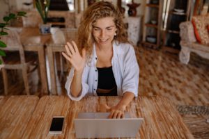 woman waving to online tutor