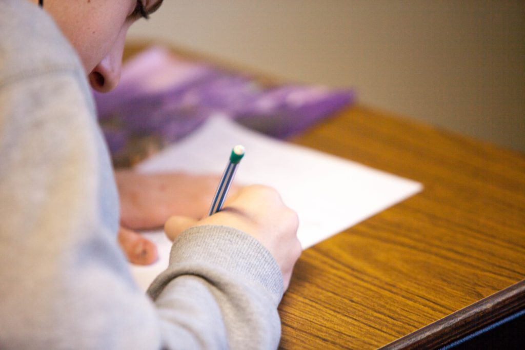 Student writing on paper