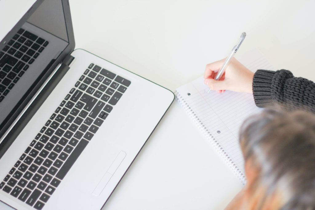 Girl taking notes with laptop