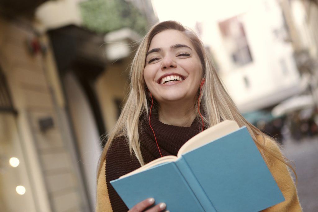 Female student smiling with book open
