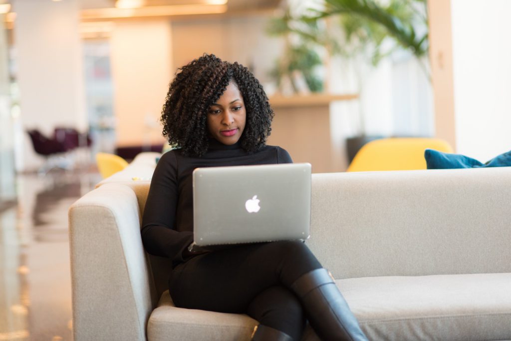 girl sitting on sofa with laptop