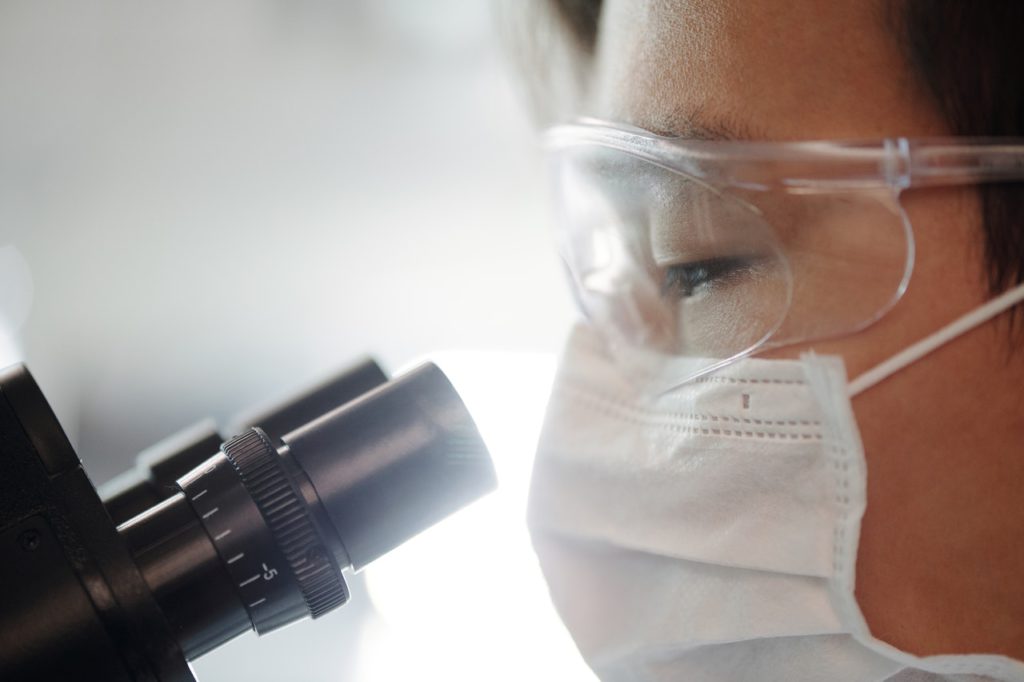 Scientist looking through microscope