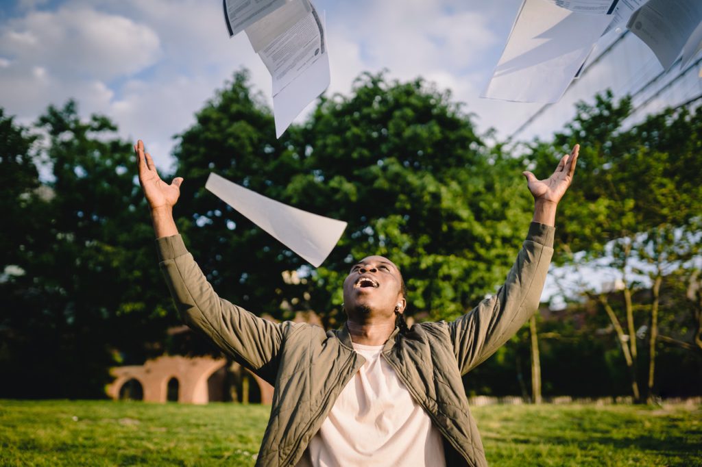 student throwing papers in the air in celebration