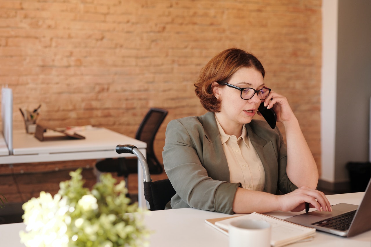 Woman sitting at desk on phone