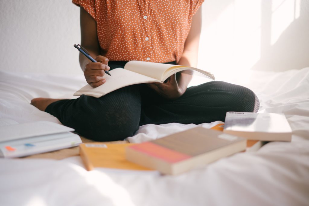 Woman studying on bed