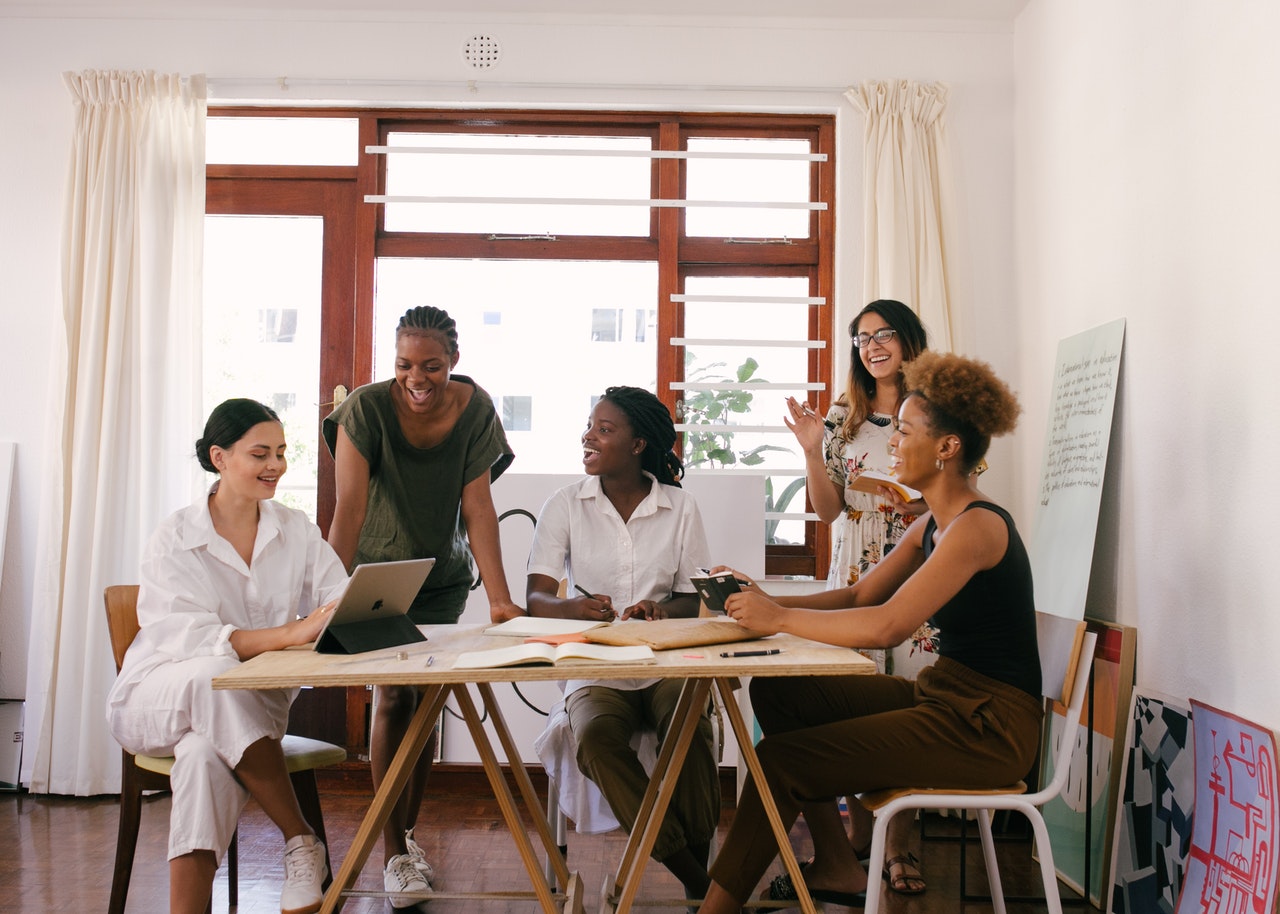 group of women smiling around a table