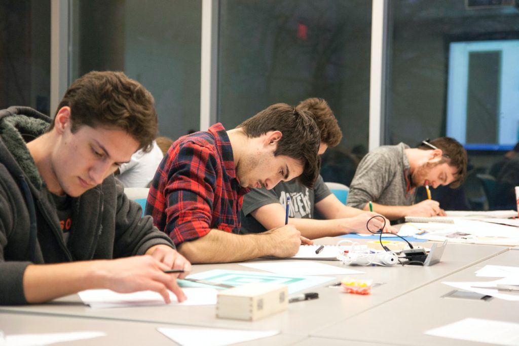 male students writing in classroom