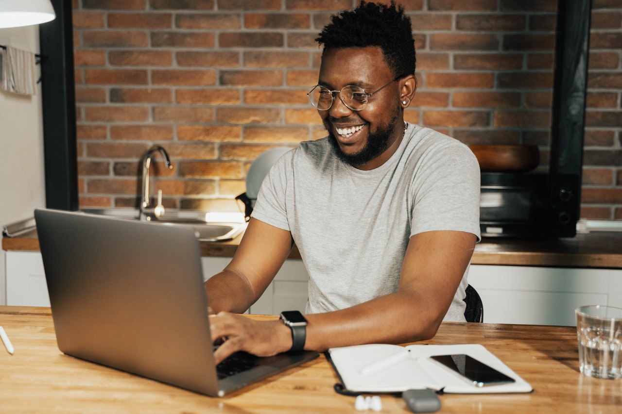 Man smiling whilst using laptop