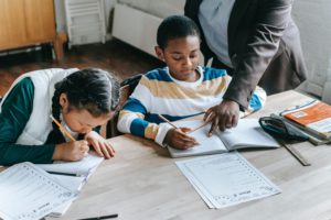 Students studying with tutor at home