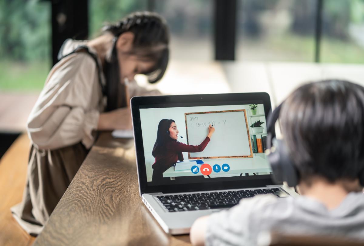 Young students using laptops to study from home