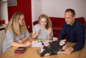 Student studying at home with her parents